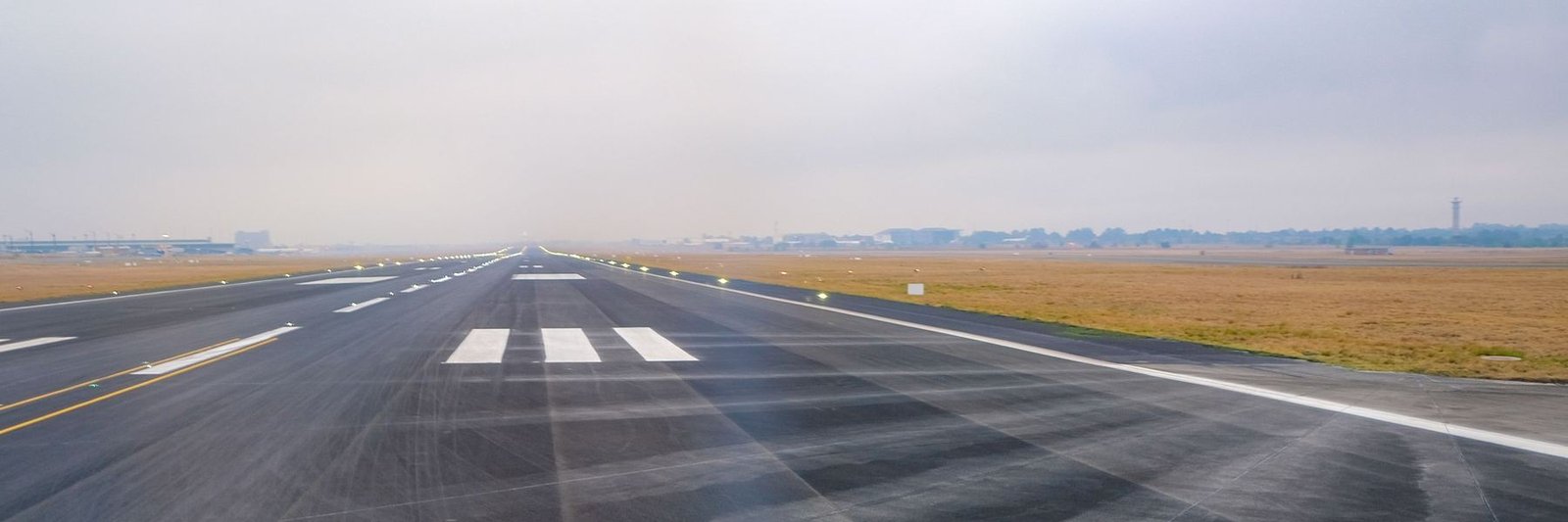 Anflugbefeuerung an einer Landebahn, die Lichter reihen sich bis zum Horizont
